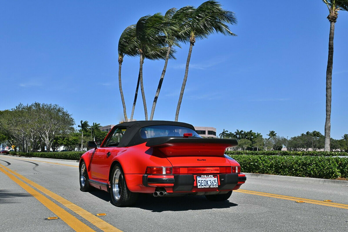 Red Porsche 930 Turbo convertible with the top up
